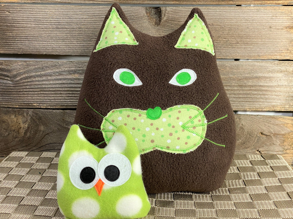 Brown cat pillow with green and brown dots and a green and white polka dot owl hot and cold pack