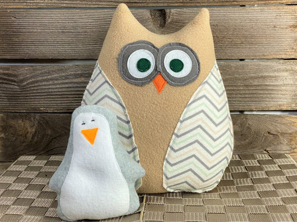 Beige owl pillow with chevron wings and a gray hot and cold penguin for boo boos