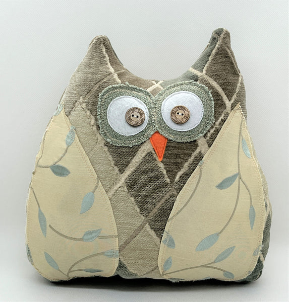 Neutral colored owl pillow with diamond shapes and embroidered wings
