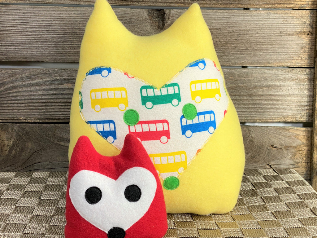 Yellow fox pillow with primary color buses and a red fox hot and cold pack